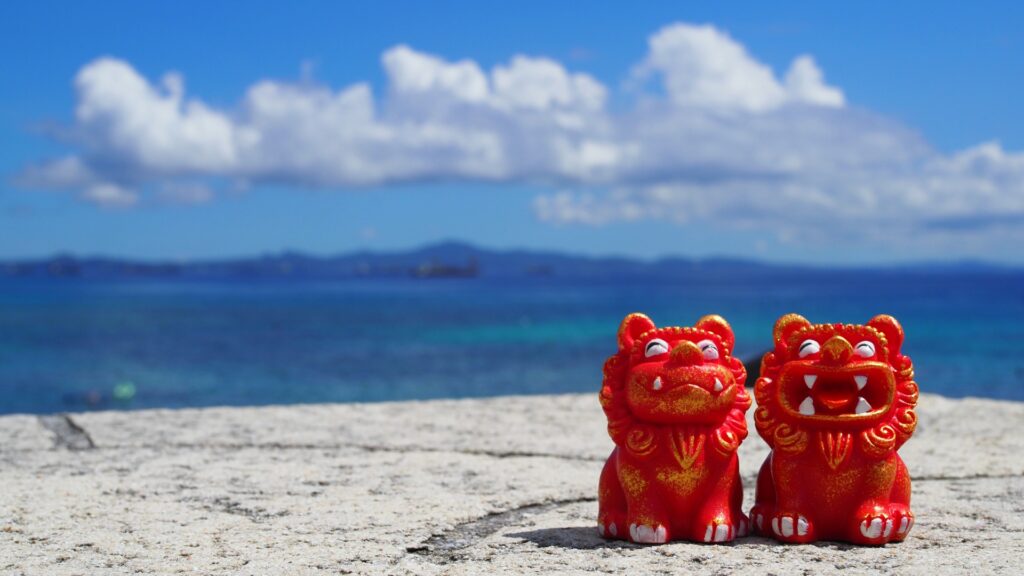 石垣島の海を背景にした赤いシーサー像。12月の石垣島旅行の雰囲気を伝える画像。