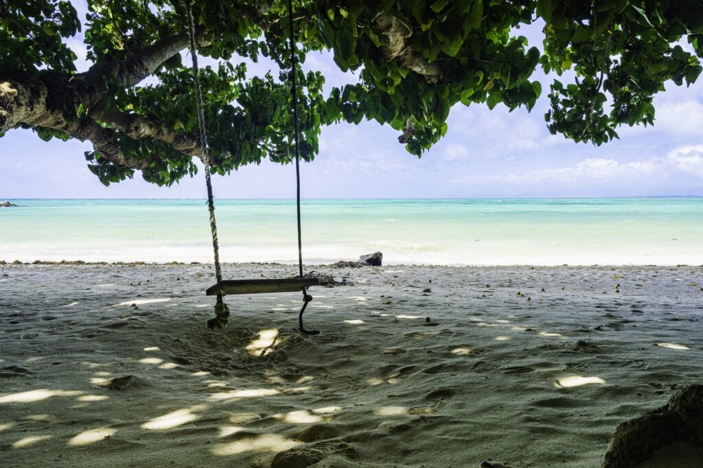 竹富島のビーチにある木陰のブランコと海の景色