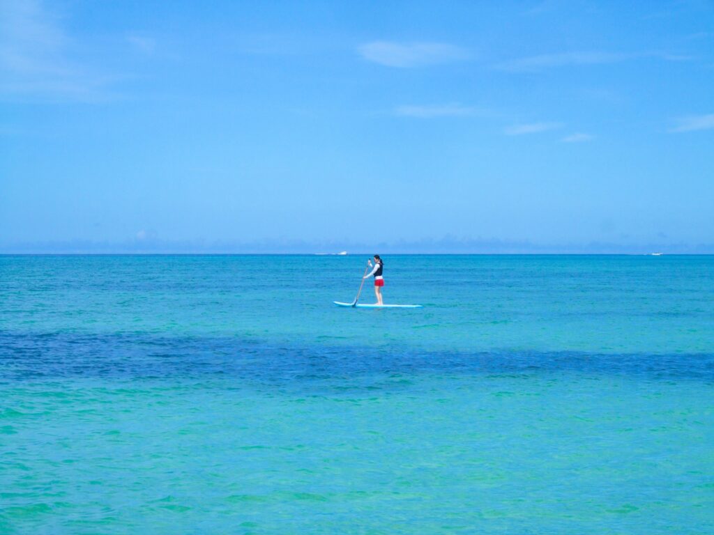 石垣島の穏やかな海でSUP体験をする旅行者
